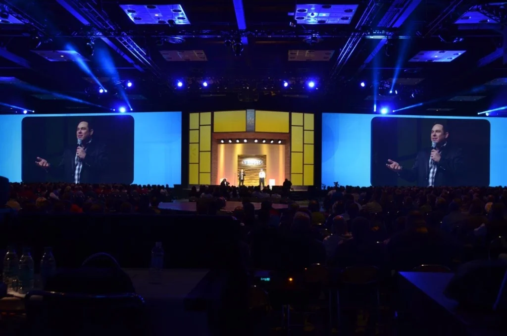 Randy Charach, been shown on big screen on a stage on one of his show