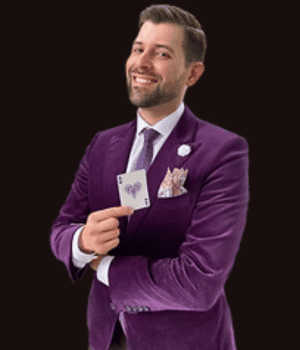 Anthony, a close-up Magician, holding a card and smiling.