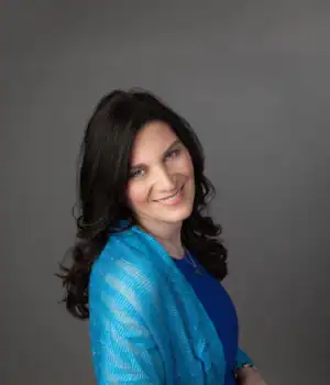 Elite Tarot, wearing a blue dress and smiling.