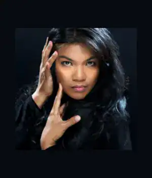 Maritess Zurbano, a portrait picture of her with her hand touching her face.